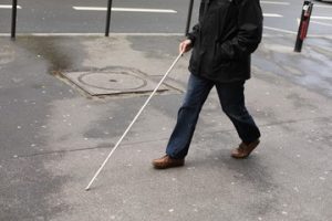 Man walking with white cane.