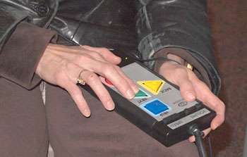 A person’s hands use an accessible voting machine.