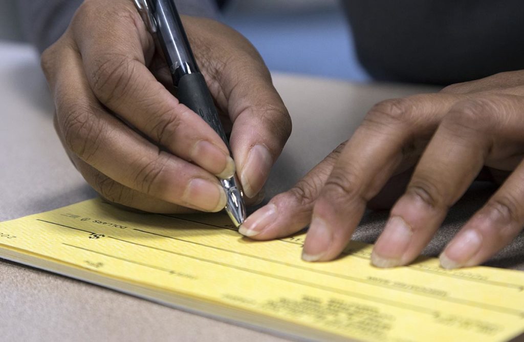 A close-up of hands writing on a large print notepad