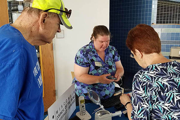 A woman at the WCBVI table shows a couple products.