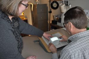 Amy Wurf, Certified Low Vision Therapist, guides a client on how to use a lighted magnifier.