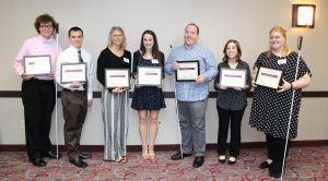 The 2019 Scholarship winners stand in a line holding their certificates.