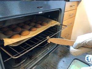 A push-pull oven ruler pulls out the oven rack holding 15 brown-colored cookies.