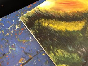 A canvas painting lays on a workbench.