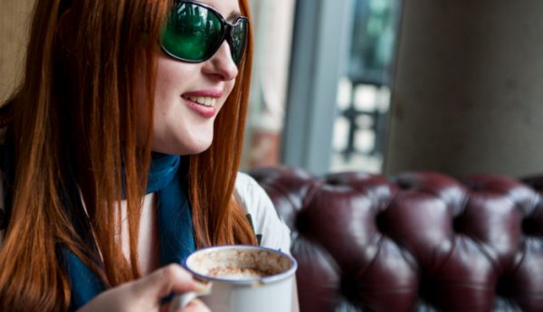 A woman holds a mug of hot chocolate.