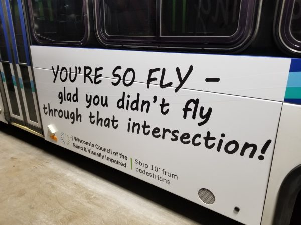 A side of a bus with an ad saying: You’re so fly – glad you didn’t fly through that intersection.