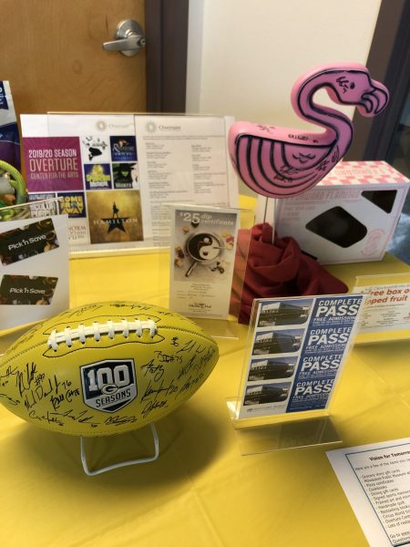 A Packers-signed football, a pink flamingo and other miscellaneous items sit on a table.