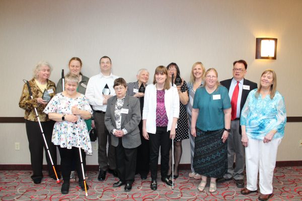A group of people, some with white canes.