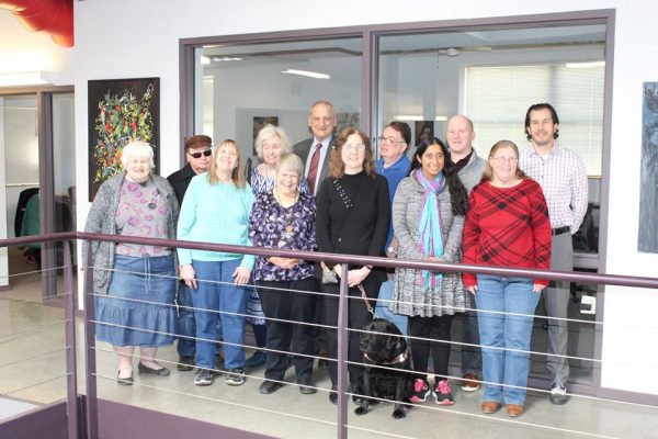 Twelve people stand inside the Council.