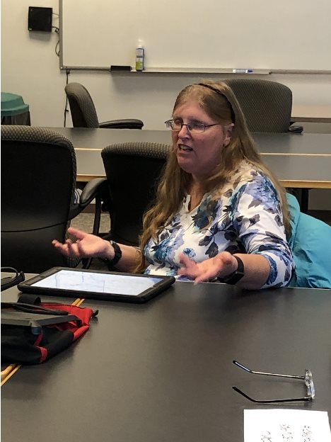 A woman talking with her hands at a table.
