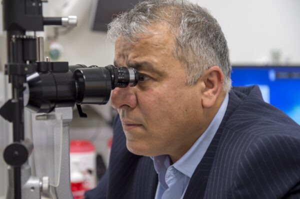 Man looks into an eye exam machine.