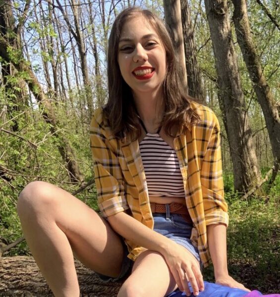 A girl sits outside in the sun.