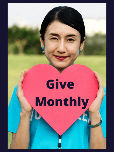 A person holding a sign posing for the camera Description automatically generated