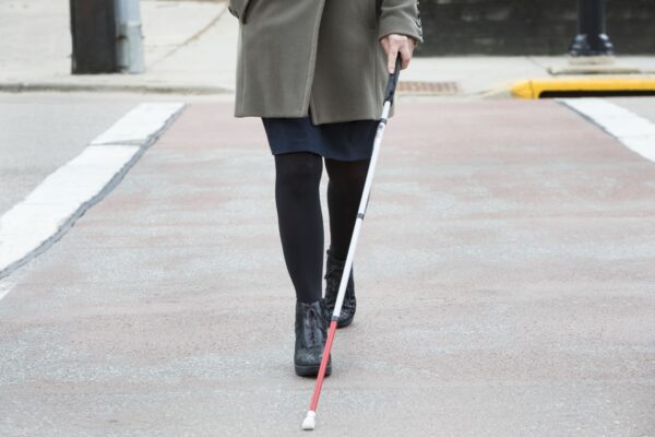 woman crossing street with cane