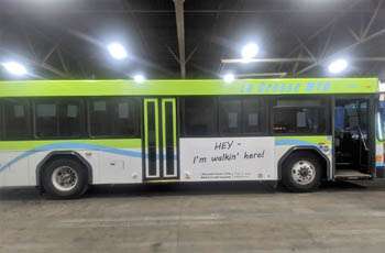 Hey I’m Walkin’ Here ad on a blue and green bus.