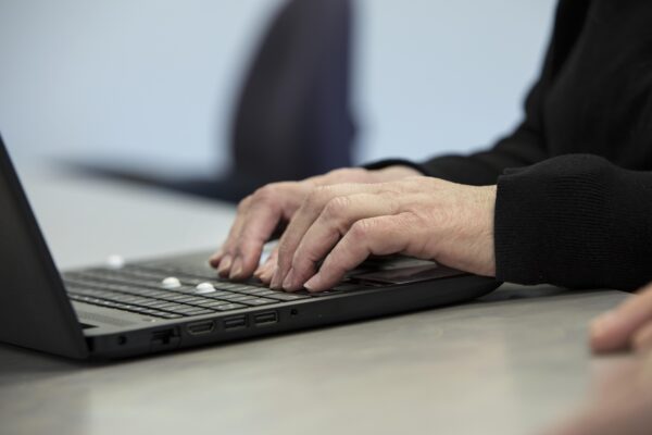 A person types on a laptop computer.