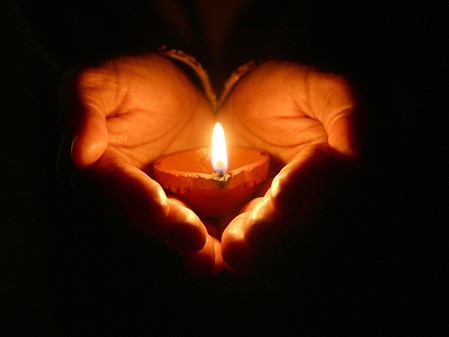 Hands holding a memorial candle