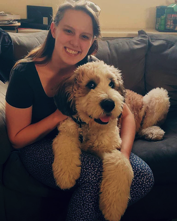 Sara Werbeckes snuggling with her dog Murphy on a sofa
