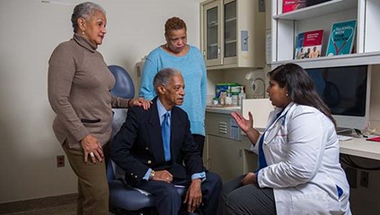 Older man with his two adult daughters at a doctors appointment
