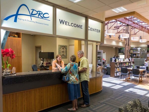 Two people being greeted at the front desk of the Brown County Aging and Disability Resource Center