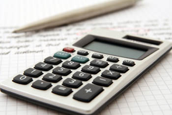 A pen and a calculator resting on graph paper