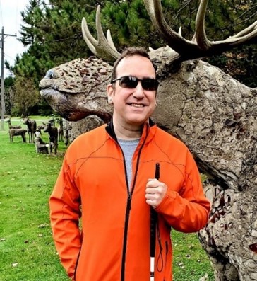 Brent Goodman standing in front of a sculpture of an antlered animal