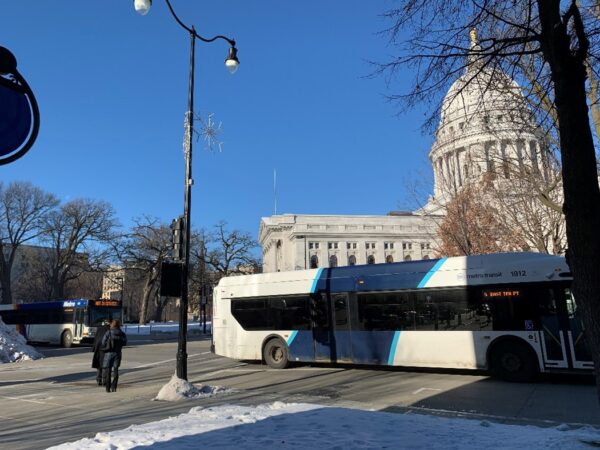 A bus driving by the Wisconsin State Capitol