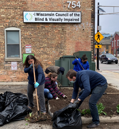Volunteers from Anderson & Shapiro cleaning up the front flower bed at the Council office