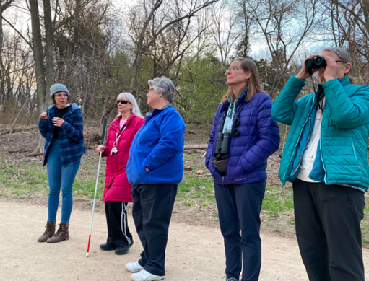 Five people watching and listening to birds