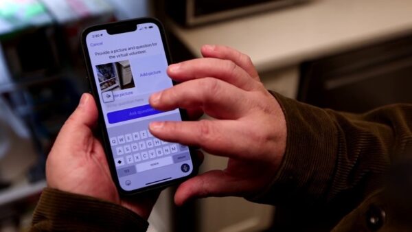 A person’s hands using the Be My Eyes app on a cell phone