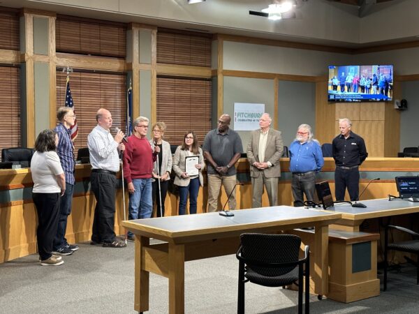 Fitchburg Common Council stand with Community members holding white canes in city hall meeting room