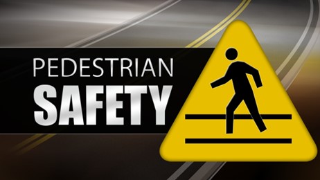 The words Pedestrian Safety and a yellow traffic sign showing a graphic of a pedestrian crossing a street