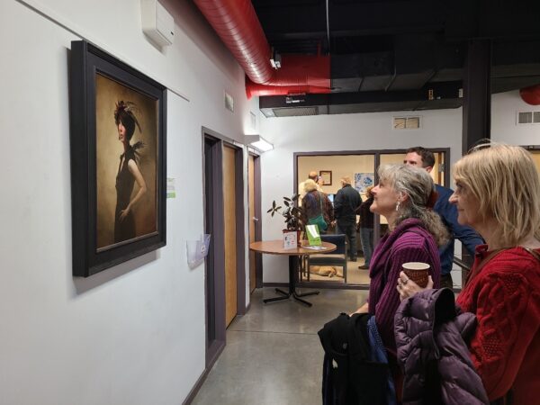 A group of people looking at a painting on a wall
