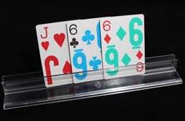 Three large-print playing cards standing up in a clear plastic card holder