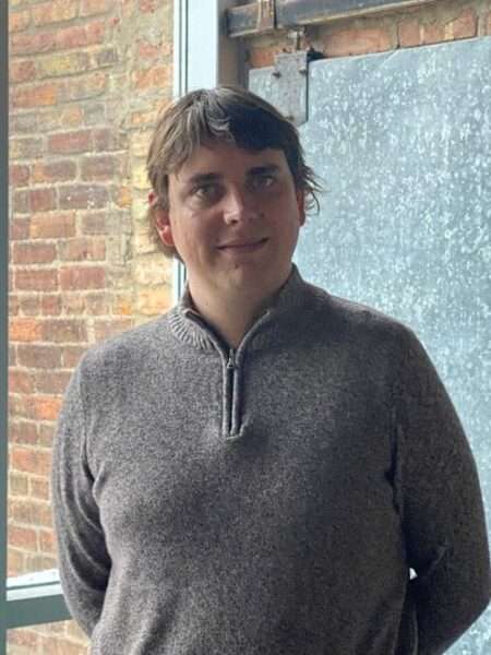 Nate Wegehaupt standing in front of a brick wall