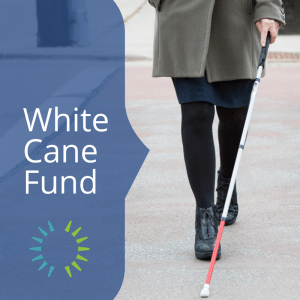 A woman walking toward the camera with a white cane and the words White Cane Fund.