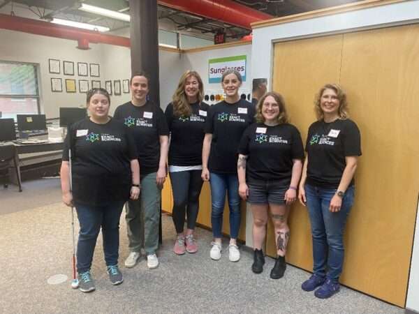 A group of six volunteers from Exact Sciences posing for the camera in the Sharper Vision Store.