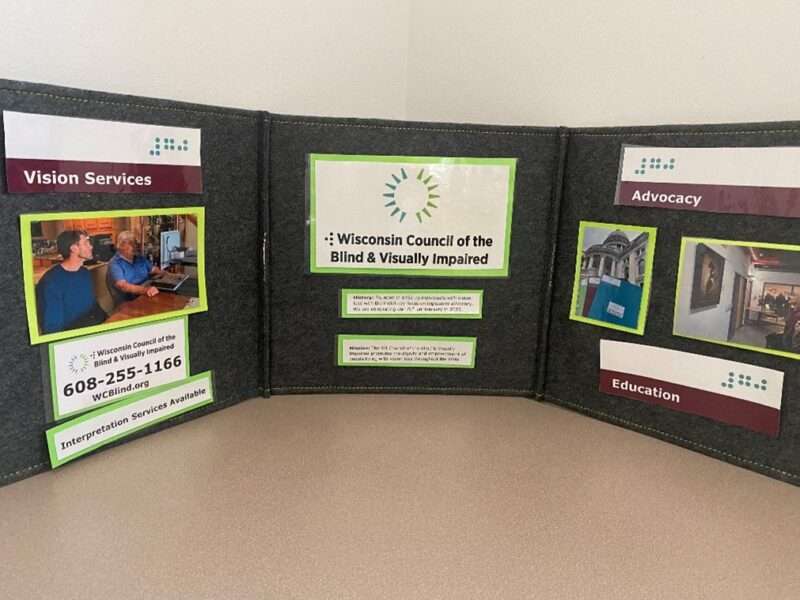 A folding table display showing the Council logo and photo examples of its vision services, advocacy and education work.