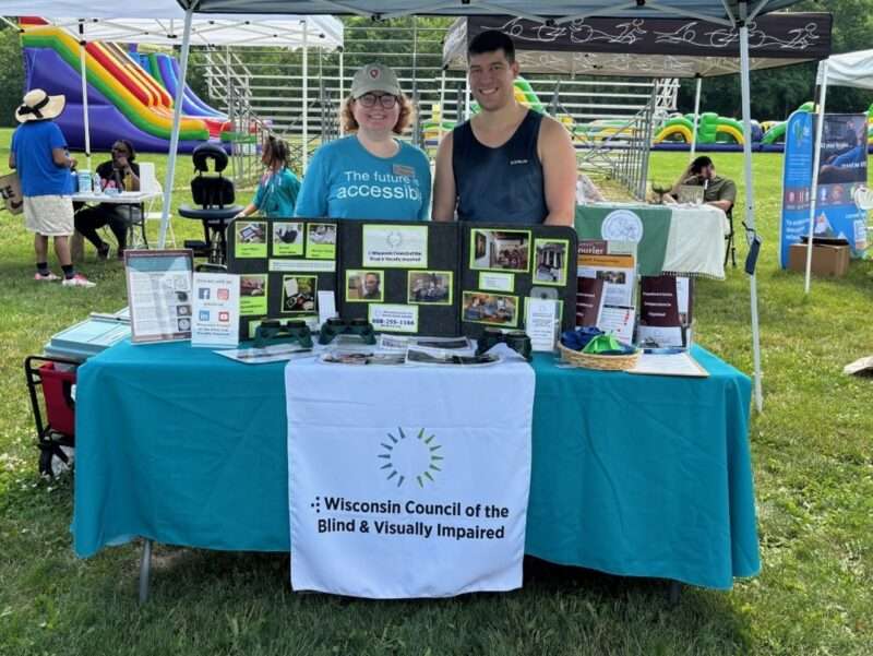 Kathleen Callen and Mitch Brey standing behind the Council's information table at the Madison Gospel Run and Health Fair.