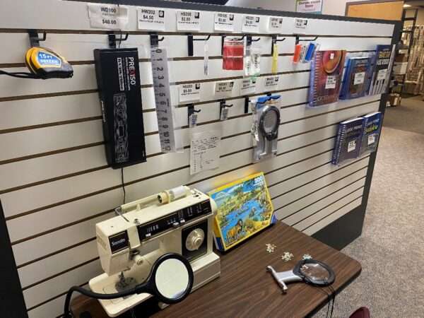 Aisle in the Sharper Vision Store containing sewing items and crossword books.