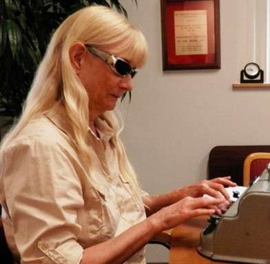 Judith Rasmussen typing on a brailler.