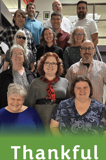 Members of the Council staff posing on a stairway with word Thankful displayed below them.