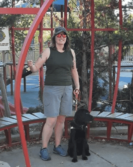 Shannon Columb and her guide dog standing in a playground.