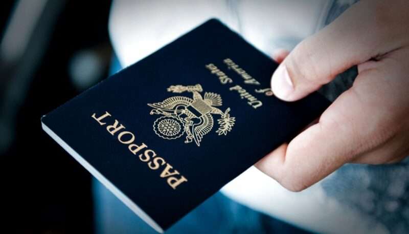 A hand holding a U.S. passport.