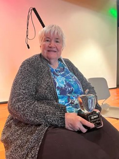 Karen Heesen holding her Crystal Apple award.
