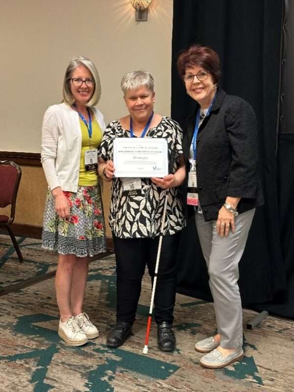Denise Jess standing between VSA President Lee Nasehi and VSA Board Chair Lauran Branch holding an award certificate.