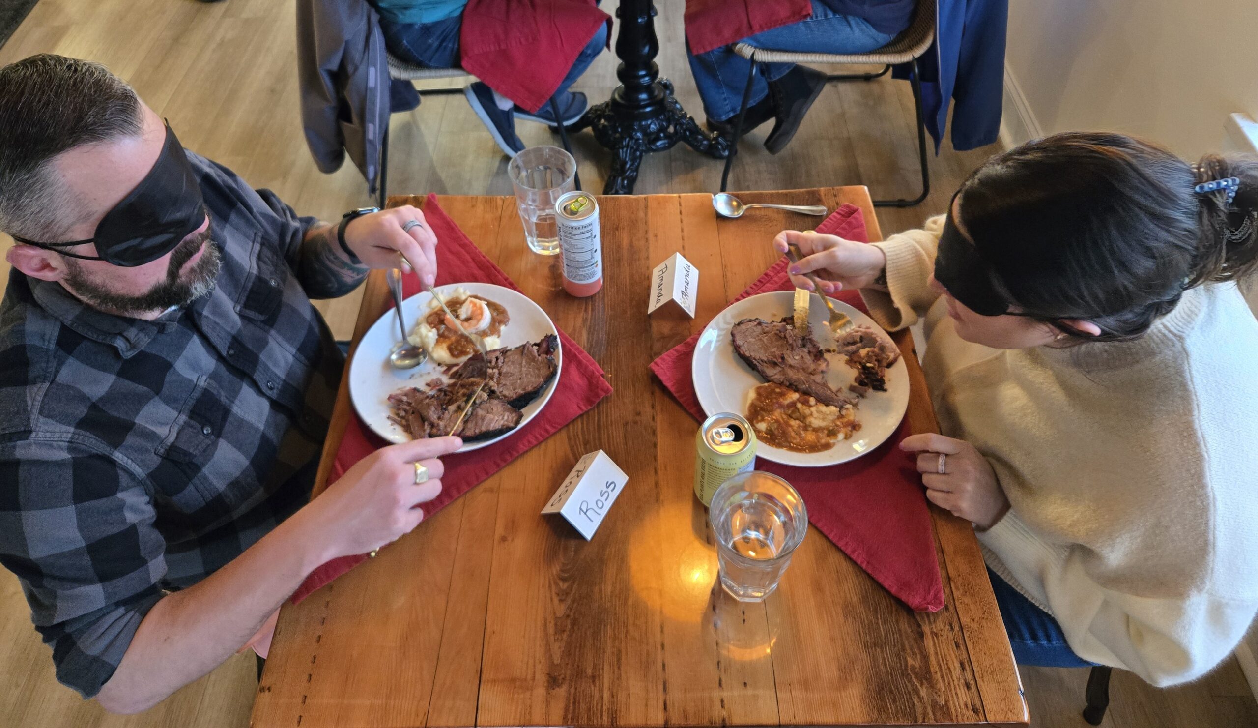 Two diners eating across from each other at a table.