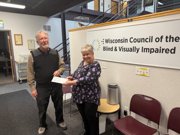 Two people holding a check in the waiting area of the Council offices