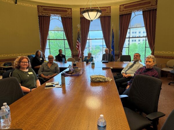 A group of people sitting around a large meeting room table.