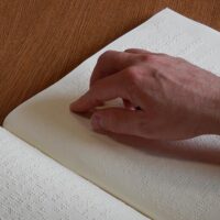 A hand reading Braille